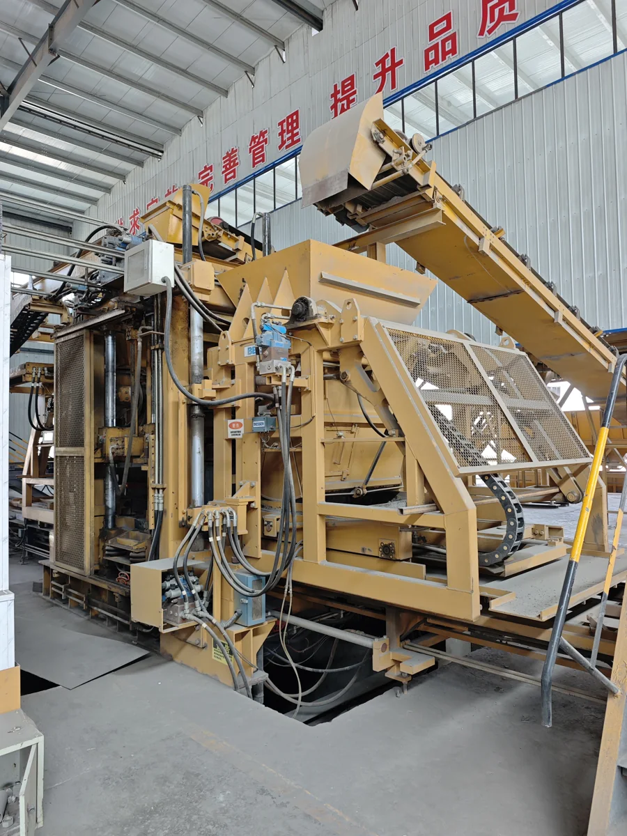 Yellow Besser equipment with a feed conveyor in an industrial building